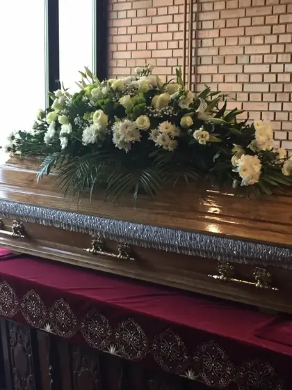 Suza od belog cveća na kovčegu