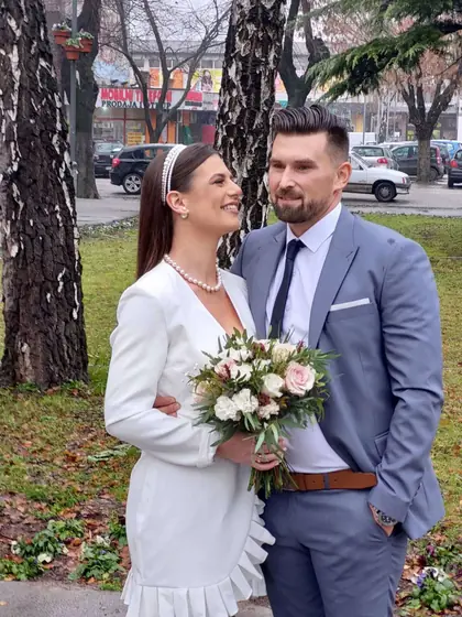 Mladenci u parku sa bidermajerom od ružičastih i belih ruža