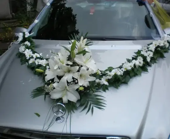 Dekoracija od belih ljiljana i zelenila na haubi automobila