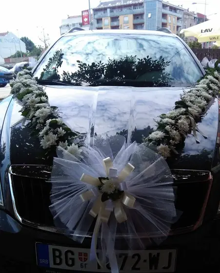 Ukras za automobil od belog cveća sa velikom mašnom od tila