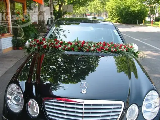 Ukras od crvenih ruža na haubi crnog automobila