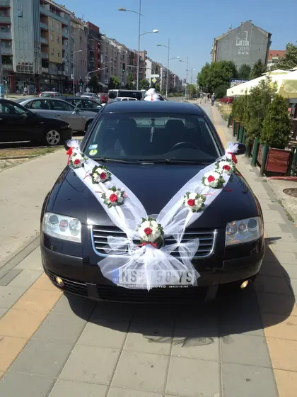 Ukras u obliku slova V od cveća i tila na crnom automobilu
