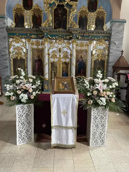 Dva aranžmana belog cveća ispred ikonostasa