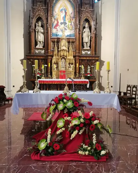 Aranžman od crvenog i belog cveća ispred oltara