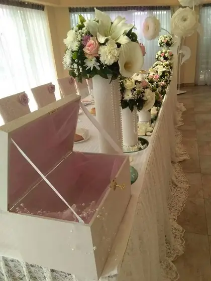 Dekoracija od kala i belog cveća uz providnu kutiju